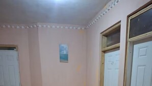 Ein Zimmer mit Holzboden, weißen Türen und einem kleinen Bild an der Wand.
