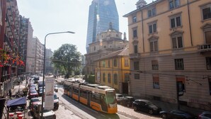 A tram on a city street with buildings and parked cars. - 5 minutes from milan central station- 3 minutes from piazza repubblica- comfort (Milano)