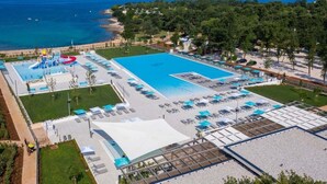 Vista aérea de um resort com uma piscina grande, parque aquático e praia.