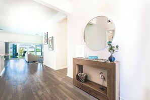 Ein modernes Interieur mit Holzboden, Kamin, Spiegel und einer Willkommensanzeige.