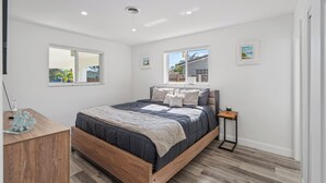 Une chambre à coucher avec un lit, une table de chevet et une fenêtre.