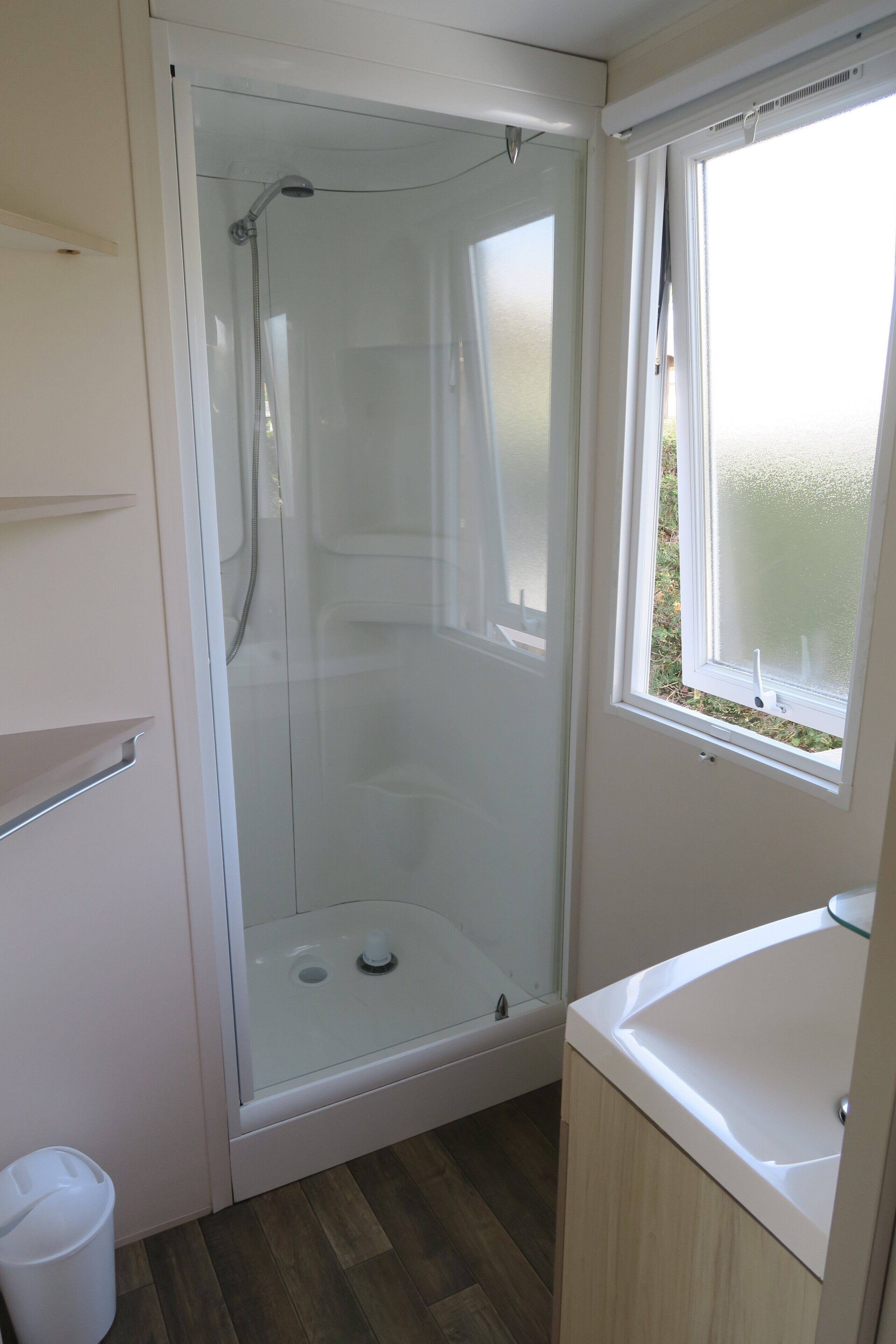 Une salle de bain avec une douche à parois de verre, une baignoire et une fenêtre.