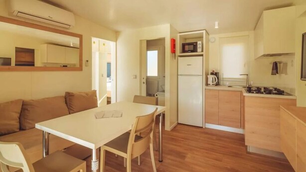 Una cocina compacta con comedor, refrigerador, microondas y estufa.