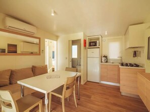 A compact kitchen with a dining area, a refrigerator, a microwave, and a stove. - Spacious Coastal Comfort Stay (Brtonigla)