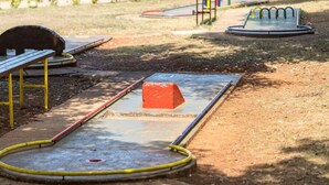 Un parque infantil con un balancín, un tobogán y una estructura para escalar.