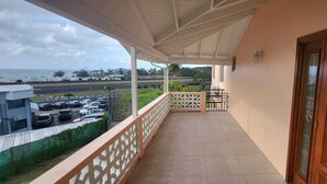 Ein Balkon mit Blick auf einen Parkplatz und einen Strand.