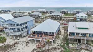 A coastal property with multiple houses, a deck, and a beach view. - Catch & Release ~ Bay Front ~ Sleeps 12 (Dauphin Island)