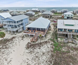 A coastal property with multiple houses, a deck, and a beach view. - Catch & Release ~ Bay Front ~ Sleeps 12 (Dauphin Island)