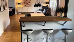 A modern kitchen with a wooden island and three bar stools. - Bright house near beach & center + free parking (Bunkeflostrand)