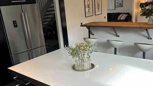 A modern kitchen with a large island, stainless steel appliances, and a minimalist design. - Bright house near beach & center + free parking (Bunkeflostrand)