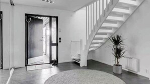 A modern interior with a staircase, a potted plant, and a large rug. - Bright house near beach & center + free parking (Bunkeflostrand)