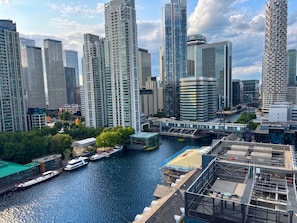 Ein hoch aufragendes Stadtbild mit moderner Architektur, einem Fluss und Booten.