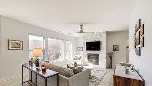 A modern living room with a fireplace, a sofa, a coffee table, and a TV mounted on the wall. - Mtn-View Retreat in Asheville: Great for Groups! (Asheville)