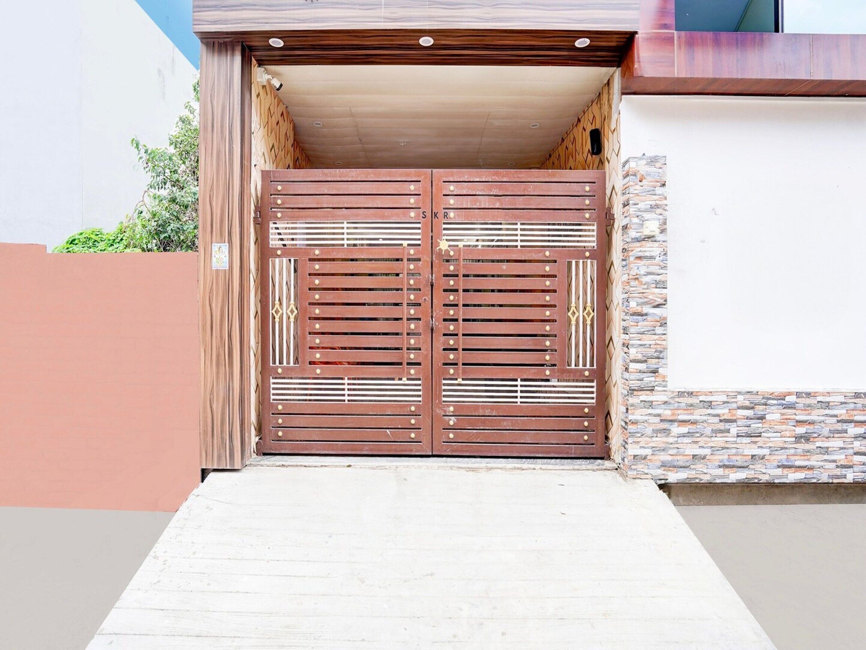 Une double porte en métal, dotée d’un cadre en bois, qui donne accès à l’entrée d’un bâtiment.
