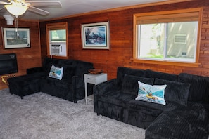 A living room with a sectional sofa, a small side table, a ceiling fan, and a large window with blinds. - Boat or WaveRunner Rentals available next door! Relax or Explore Lake Winnebago! (Fond du Lac)