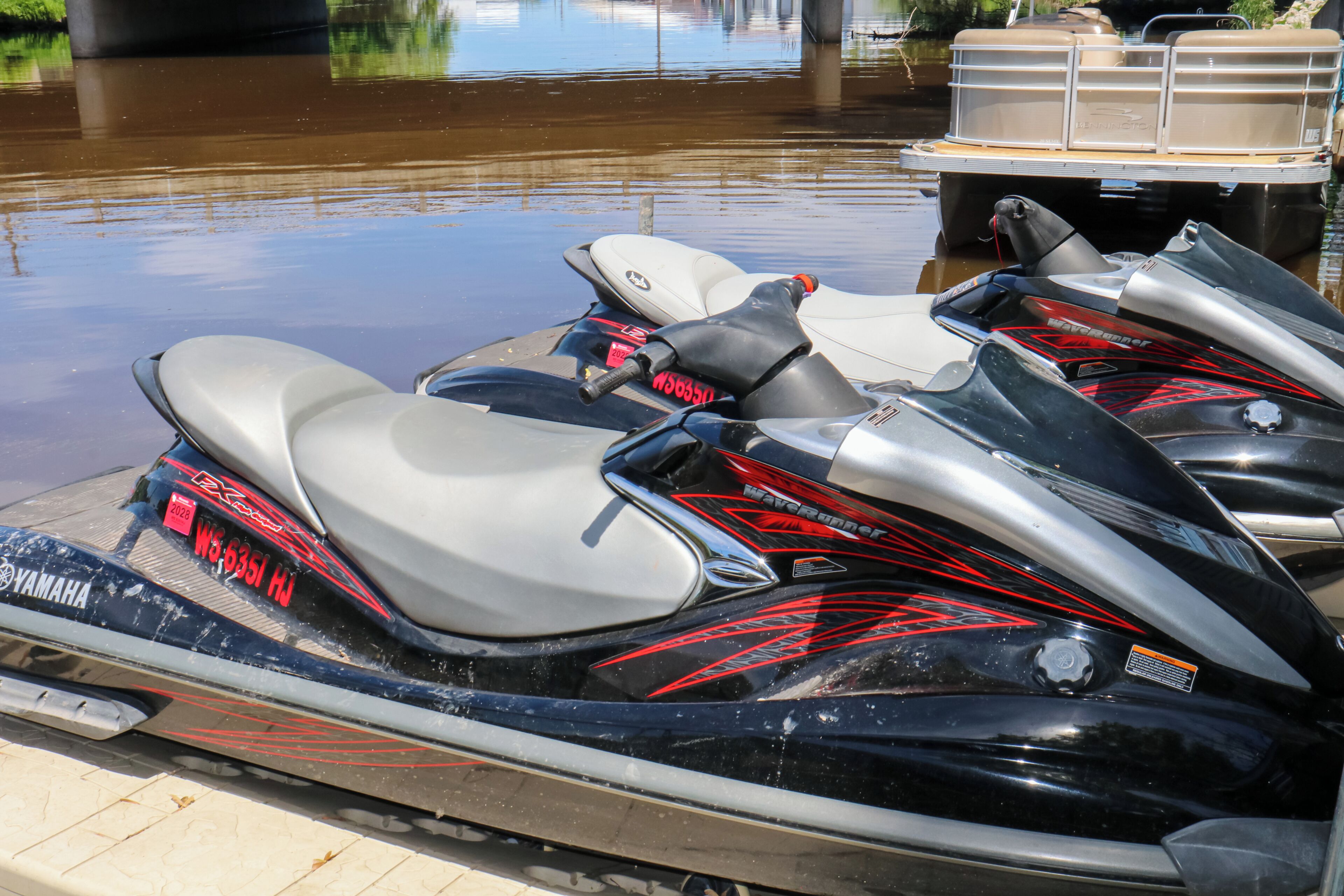 Un jet ski avec une plaque d’immatriculation et une remorque dotée de compartiments de rangement.
