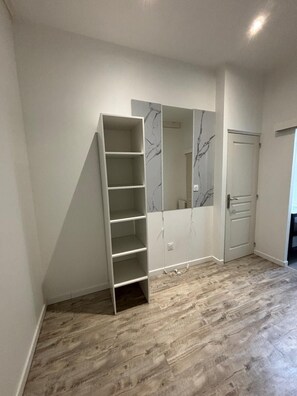 A room with a built-in wardrobe, a door, and a patterned floor. - Modern 3-bedroom house with terrace and parking (Sallebœuf)