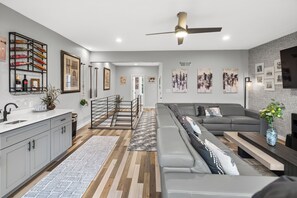 Un salon moderne avec un canapé gris, une table basse et un téléviseur.