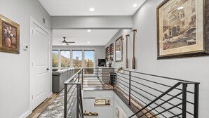 A modern interior with a staircase, a view to the outside, and a bookshelf. - Hot tub, BBQ, Fire pit, Garage, Near Downtown (Pittsburgh)