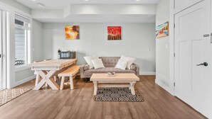 Ein modernes Wohnzimmer mit Holztisch, einer Couch und einem Couchtisch.