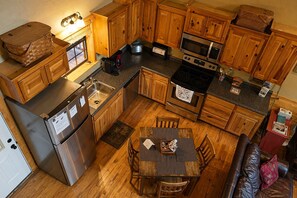 Une cuisine compacte dotée de meubles en bois, d’un réfrigérateur en acier inoxydable, d’un four à micro-ondes et d’une cuisinière.