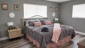 Ein Schlafzimmer mit Bett, Nachttischen und Wanddekorationen.