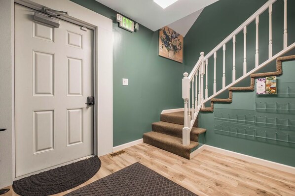 A staircase with carpeted steps, a white door, and a wall-mounted bulletin board.