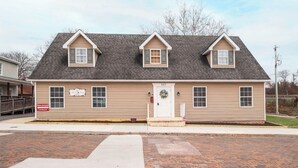 A two-story building with a front porch, a garage, and a driveway.