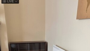 A white table and chair in a room with wooden flooring and a radiator.