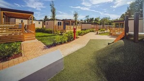 A row of mobile homes with a paved walkway and green lawn. - Relaxing Premium Family Lounge (Brtonigla)