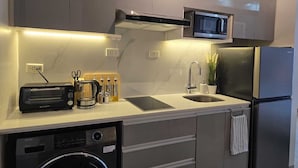 Una cocina compacta equipada con microondas, tostadora, fregadero y lavavajillas.
