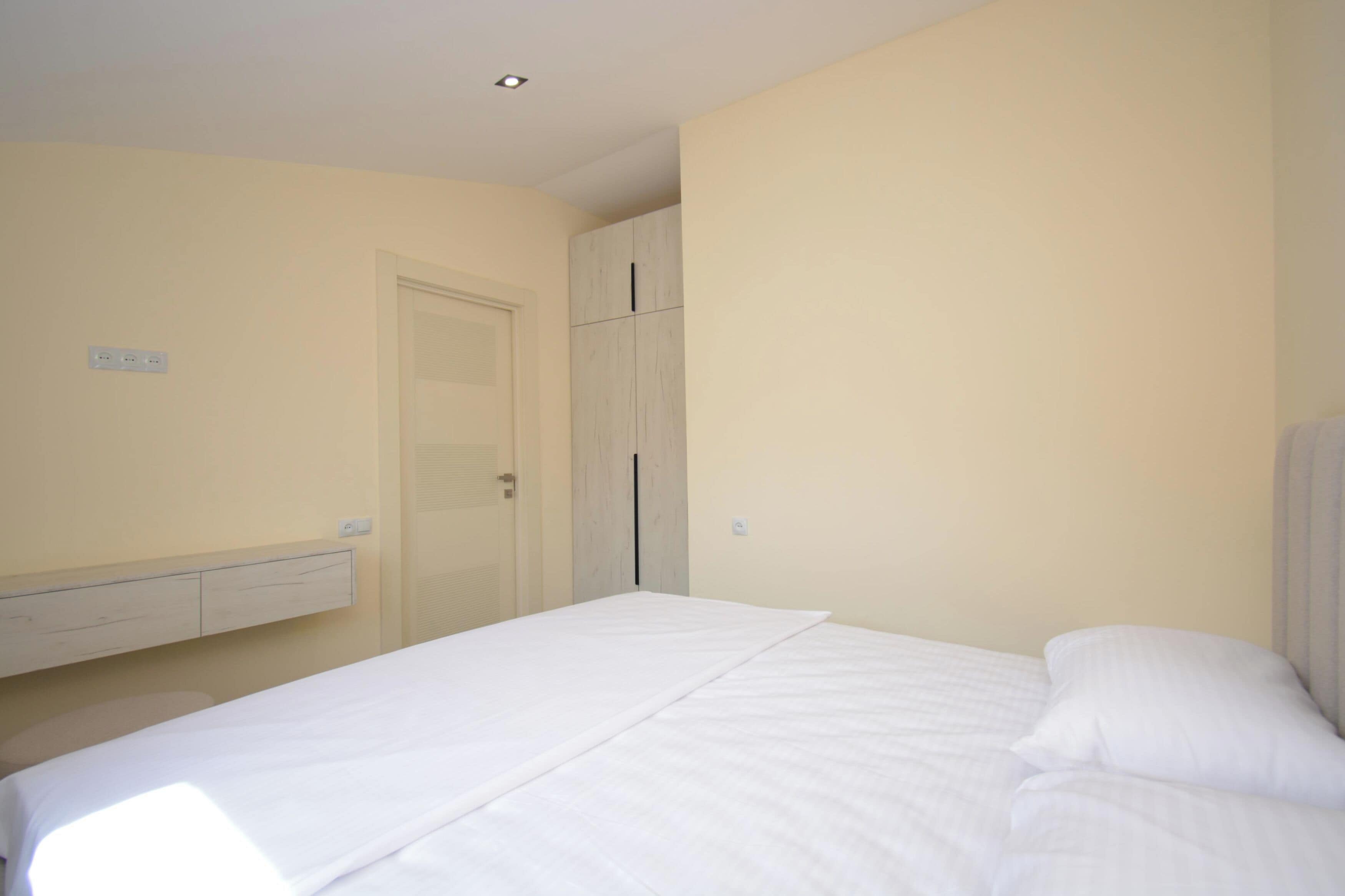 Un dormitorio con cama, armario y puerta.