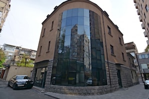 Un edificio curvo con fachada de vidrio que refleja edificios cercanos.