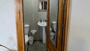 A bathroom with a toilet, sink, and two baskets. - w cabañas beach (Cartagena)