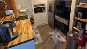 Une cuisine moderne avec des armoires blanches, un réfrigérateur en acier inoxydable, un four et un four à micro-ondes.