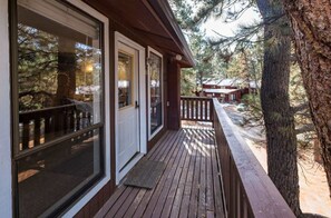A wooden deck with glass doors, surrounded by trees. - Updated 2-bedroom condo in Angel Fire 1 BLOCK FROM LIFTS (Angel Fire)