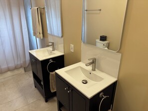 A bathroom with two sinks, a mirror, a towel rack, and a toilet. - 3-bedroom house w/ AC in charming Atlanta, close to stadium - newly renovated (Atlanta)