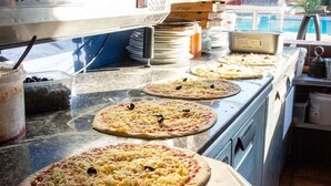 A kitchen with multiple pizza ovens, pizza toppings, and pizza boxes. - Seaside Holiday Home for Four (Hyères)