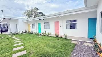 A modern building with multiple doors, a well-maintained lawn, and a gravel pathway.