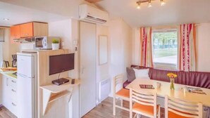 A compact kitchen with a microwave, a refrigerator, and a flat-screen TV. - Comfort Mobile Home by Sea for 6 (Brtonigla)