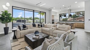Ein modernes Wohnzimmer mit einem Ecksofa, einem Couchtisch und Blick ins Freie.