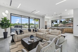 Ein modernes Wohnzimmer mit einem Ecksofa, einem Couchtisch und Blick ins Freie.