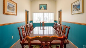 A conference room with a long table, wooden chairs, teal walls, and framed pictures on the walls. - 3 Bedroom Penthouse (Port Clinton)