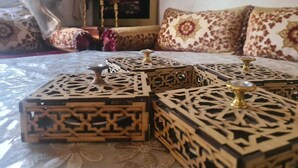 A room with a bed, patterned pillows, and decorative wooden boxes. - A comfortable family apartment in tangier. (Tanger)