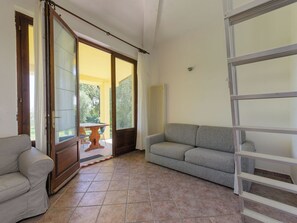 Ein Wohnzimmer mit Sofa, Sessel, einer Schiebetür und einer Heizung.