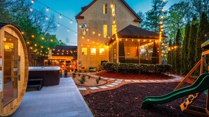 A house with a hot tub, a covered patio, and a play area. - Sleeps 20 • 15 Mins to DT AVL • Sauna • Hot Tub! (Fletcher)