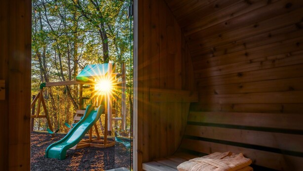 A wooden cabin with a bench and a view of a playground. - Sleeps 20 • 15 Mins to DT AVL • Sauna • Hot Tub! (Fletcher)