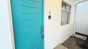 Une porte turquoise avec un trou de serrure et un bouton de sonnette.