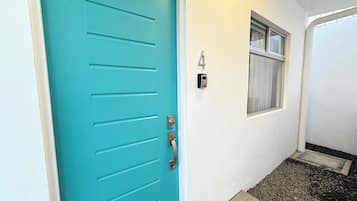 A turquoise door with a keyhole and a doorbell.