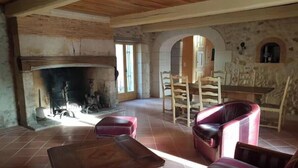 Un intérieur rustique avec une cheminée, des meubles en bois et des murs en pierre.